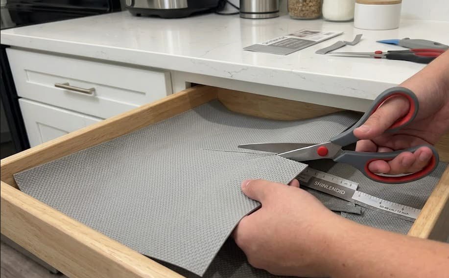 Measuring and cutting thick drawer liner with scissors